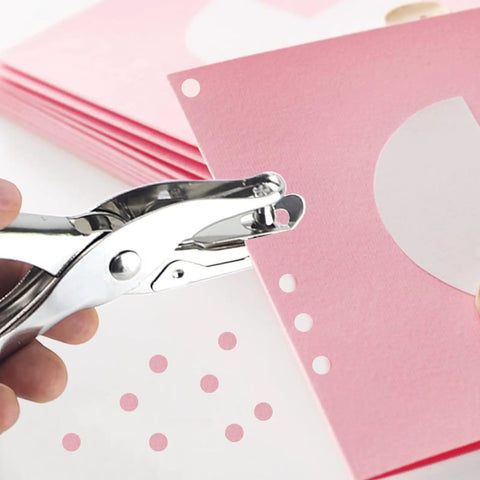 Two Piece Metal Hole Punch Set With One Quarter Inch And One Eighth Inch Single Hole Punches used on pink paper for crafting.