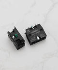 Slick Heavy Duty Green Push Button Switch Rugged 600 Volt 10 Amp Normally Open Contact Block with silver terminals, side view.