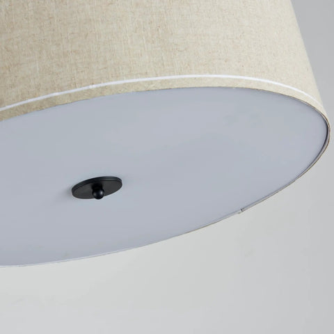 Bottom view of beige drum pendant chandelier with white linen shade and black rod, showcasing cozy modern rustic warm glow.