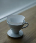 V60 Cone Pour Over Coffee Filters Size 02 White 600 Count Unbleached Single Use Paper Filters in dripper on wooden surface
