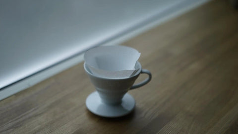 V60 Cone Pour Over Coffee Filters Size 02 White 600 Count Unbleached Single Use Paper Filters in dripper on wooden surface