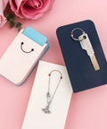 Versatile Hangtag Punch For DIY Jewelry Displays And Card Tags tool on a pink surface with jewelry and key displayed