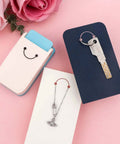 3 In 1 Hangtag Punch Kit with Portable Hole Punch, keychains, jewelry displays, and cardstock on a pink background