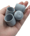 Keep It Chill And Quiet By Adding Durable Gray Plastic Chair Leg Caps To Your Folding Chairs And Dining Sets Smooth 7/8 Inch Furniture Bumpers shown in hand.