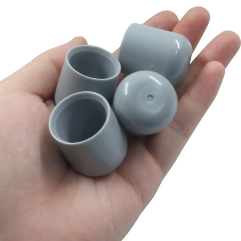 Keep It Chill And Quiet By Adding Durable Gray Plastic Chair Leg Caps To Your Folding Chairs And Dining Sets Smooth 7/8 Inch Furniture Bumpers shown in hand.