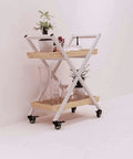 Heavy Duty Kitchen Storage Cart With Three Tier Rust Resistant Metal Frame And Tempered Glass Top Industrial Style Serving Trolley For Home Bars Wines And Salon Gear Hella Spacious Design with plants and glasses on shelves.