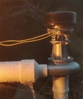 Close-up of Impact Type Portable Hydropower Turbine Generator 1000W 220V for home use, showing pipes and water flow mechanism at dusk.