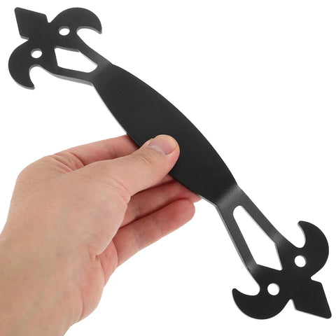 Person holding black iron cabinet door handle, vintage metal pull visible, for dresser drawers and wardrobes, farmhouse chic.