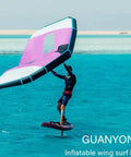 Person using Inflatable Wing Foil With Handheld Wing, Surf Wing And Wind Foil, in blue water, wearing wetsuit.