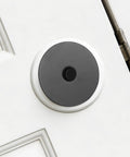 Heavy Duty Stainless Steel Decorative Deadbolt Cover Plate For Entry Doors with black round filler installed on white door.