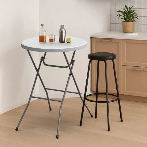 32 Inch Plastic Folding Round Bar Height Table With Gray Metal Finish For Outdoor Parties Cafes Restaurants Backyard Weddings Durable HDPE Construction 350 Lb Capacity Easy Setup White beside a black stool in a modern kitchen setting