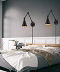 Bedroom scene with set of 2 swing arm plug in wall lamps with dimmable switch, industrial black metal reading sconces above bed.