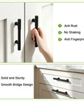 Hand using Ten Pack Three Inch Hole Centers Matte Black Solid Cabinet Handles And Drawer Pulls for cupboards