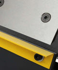 Close-up of Beefy 24 Inch Box And Pan Brake Hand Metal Bending Tool in use, showcasing metal clamp and yellow base detail.