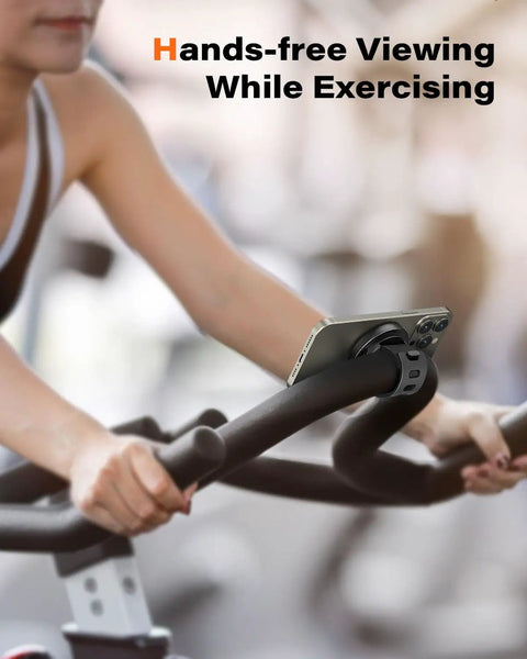 Woman using MagSafe Gym Phone Mount With 17 N54 Strong Magnets Adjustable Strap 3 In 1 Phone Holder on exercise bike handlebars.