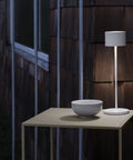 Super Sleek Portable LED Lamp In Warm Gray on outdoor table, Farol Mobile Light, Perfect For Home Or Desk, Battery Powered And Easy To Move