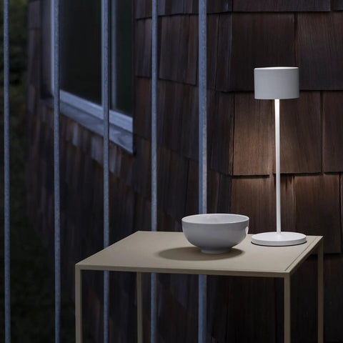 Super Sleek Portable LED Lamp In Warm Gray on outdoor table, Farol Mobile Light, Perfect For Home Or Desk, Battery Powered And Easy To Move