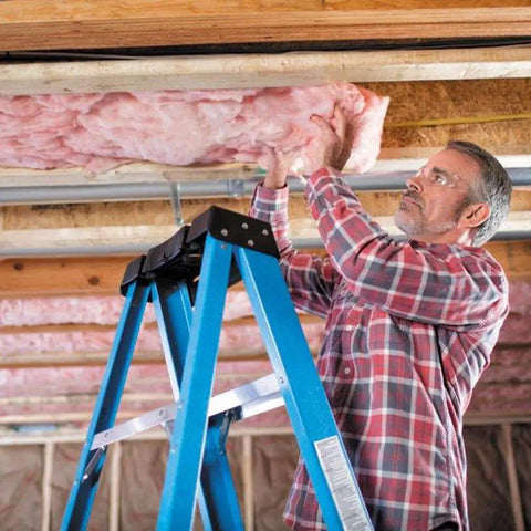 Premium Pink Fiberglass Insulation Batts For Interior Walls And Attic Cavities Heavy Duty unfaced man installing insulation on a ladder