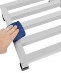 Cleaning the Stainless Steel Dunnage Rack Set 2 Pack 14x14x4 Inches Heavy Duty Floor Racks with a cloth, showing anti-slip footpads.