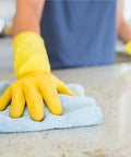 Person using a blue microfiber cloth and yellow gloves to clean a countertop with Heavy Duty All Purpose Cleaner And Degreaser One Gallon Hella Effective At Cutting Through Grease Grime And Gunky Buildup For Kitchen Countertops Appliances Walls Cabinets And Floors Works Like Butter Daily.