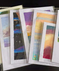 Ultra Clear 4-5/8 In By 5-3/4 In A2 Card Sleeves Resealable Cellophane Bags Self Adhesive Closure Fits A2 Envelopes Great For Photos Jewelry Candy Treats Cookies 200 Count holding colorful art prints