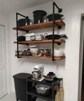 Industrial Pipe Shelving Kit 55 Inch Tall 5 Tier DIY Wall Mounted Iron Pipe Bracket System Matte Black Heavy Duty Shelving With Customizable Lengths Fits Standard 12 Inch Boards 11.25 Inch Deep installed in kitchen with cookware and appliances.
