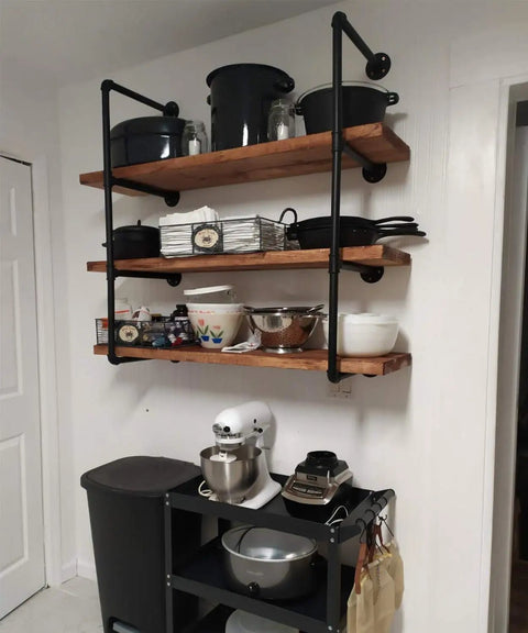 Industrial Pipe Shelving Kit 55 Inch Tall 5 Tier DIY Wall Mounted Iron Pipe Bracket System Matte Black Heavy Duty Shelving With Customizable Lengths Fits Standard 12 Inch Boards 11.25 Inch Deep installed in kitchen with cookware and appliances.