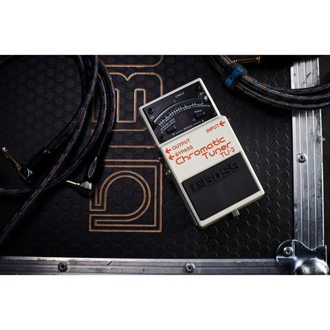 Compact Chromatic Tuner Pedal for Guitar and Bass with 21-Segment LED Meter placed on a stage-ready setup.