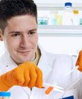 Inspire ULTRA 8 Mil orange nitrile gloves, diamond-textured, worn by lab technician.