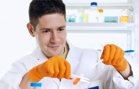 Inspire ULTRA orange nitrile gloves, 8 mil heavy-duty, latex-free with diamond-textured grip, worn by lab technician.