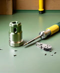 Assembly of a green and silver metal tool set with screws on a workbench.