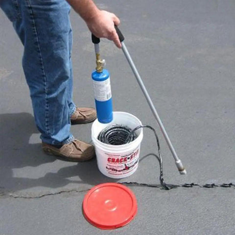 Man applying 125 Feet Of Blacktop Crack Filler For Asphalt And Concrete Weather Resistant No VOCs Pro Grade Deep Cracks And Joints