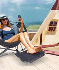 Person relaxing in Heavy Duty Hammock Style Camping Chair With Stand And Footrest, Rocker High Back Seat With Cup Holder on patio