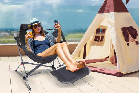 Person relaxing in Heavy Duty Hammock Style Camping Chair With Stand And Footrest, Rocker High Back Seat With Cup Holder on patio