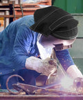 Worker welding with helmet showing extended welding helmet cover with press fit seal for pro grade protection in use.