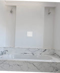 Bathroom wall with a self-adhesive wall repair patch installed near a marble bathtub. 12 Pack Self-Adhesive Wall Repair Patches For Drywall.