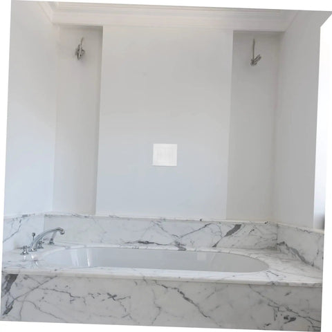 Bathroom wall with a self-adhesive wall repair patch installed near a marble bathtub. 12 Pack Self-Adhesive Wall Repair Patches For Drywall.