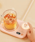 Portable Digital Cup Warmer With Three Heat Settings Hits The Spot Every Time Keeps Your Daily Brew Steaming Hot Sleek Coaster For Office Desk Dorm Rooms on a light surface with a glass mug.