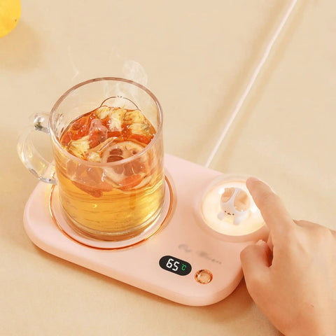 Portable Digital Cup Warmer With Three Heat Settings Hits The Spot Every Time Keeps Your Daily Brew Steaming Hot Sleek Coaster For Office Desk Dorm Rooms on a light surface with a glass mug.