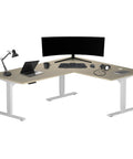 Top Shelf Electric Height Adjustable L Shaped Corner Desk With Legit Silent Lift 72 By 60 Inch Sit Stand Computer Workstation Bright Beech Top White Frame, equipped with monitor and accessories.