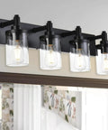 4 Light Vanity Fixture With Crystal Clear Glass Shades In Matte Black Industrial Style mounted over a bathroom mirror