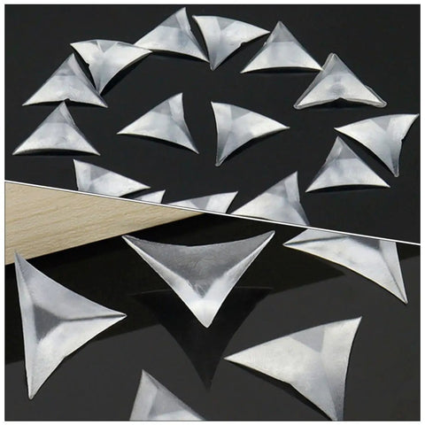 Clear transparent triangular corner protectors, 400 count, shown on black surface, part of Triangular Corner Protectors For Furniture And Drawers, 400 Count Clear Dust Guards, Safe Melamine Material, Easy Fit For Desks, Cabinets, Closets, And Stairs, Kid And Pet Safe, Keeps Edges Scratch Free.