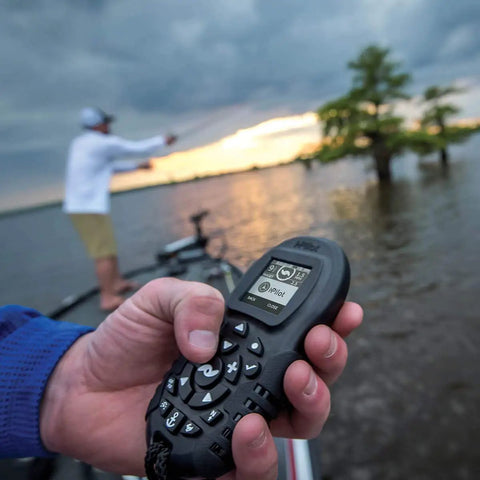 Angler holding Extra Bluetooth I Pilot System Remote For Trolling Motors with large LCD and ergonomic buttons on a boat.