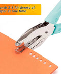 Close-up of blue Two Pack Handheld Heart And Star Shape Hole Punches With Ergonomic Soft Grip used on orange paper
