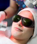 Person wearing laser safety glasses with green absorption lens during a laser treatment session