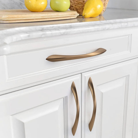 Champagne bronze 5-inch cabinet pulls installed on white kitchen cabinets, part of 10 Pack 5 Inch Champagne Bronze Cabinet Pulls Set For Cabinets And Drawers Kitchen Cupboard Hardware Dresser Handles Durable Zinc Alloy Construction Smooth Satin Finish Easy Grip.