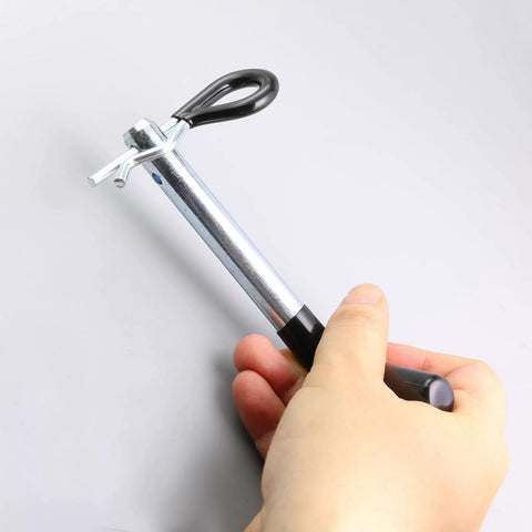 Hand holding Half Inch Trailer Hitch Pin With Black Vinyl-Coated Grip And R Clip, Fits 1-1/4 Inch Receivers