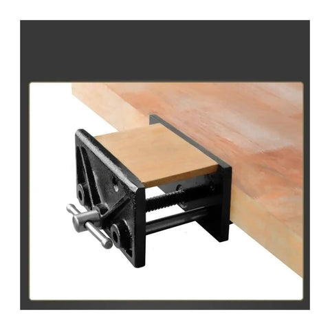 Heavy Duty 6.5 Inch Table Clamp With Rock Solid Quick Release Vise mounted on a wooden bench holding a piece of wood securely.