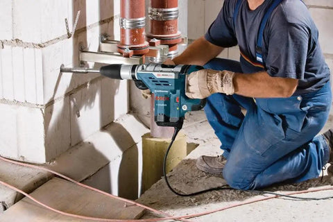 Worker using Heavy-Duty SDS Max Rotary Hammer Drill, 13 Amp, 120V on a concrete wall, showing vibration control in action