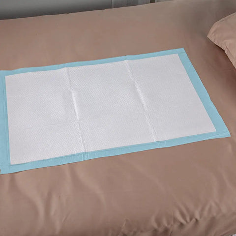 Straight Up Reliable Disposable Underpads For Adults Super Absorbent Leak Proof Incontinence Bed Pads on a bed surface.